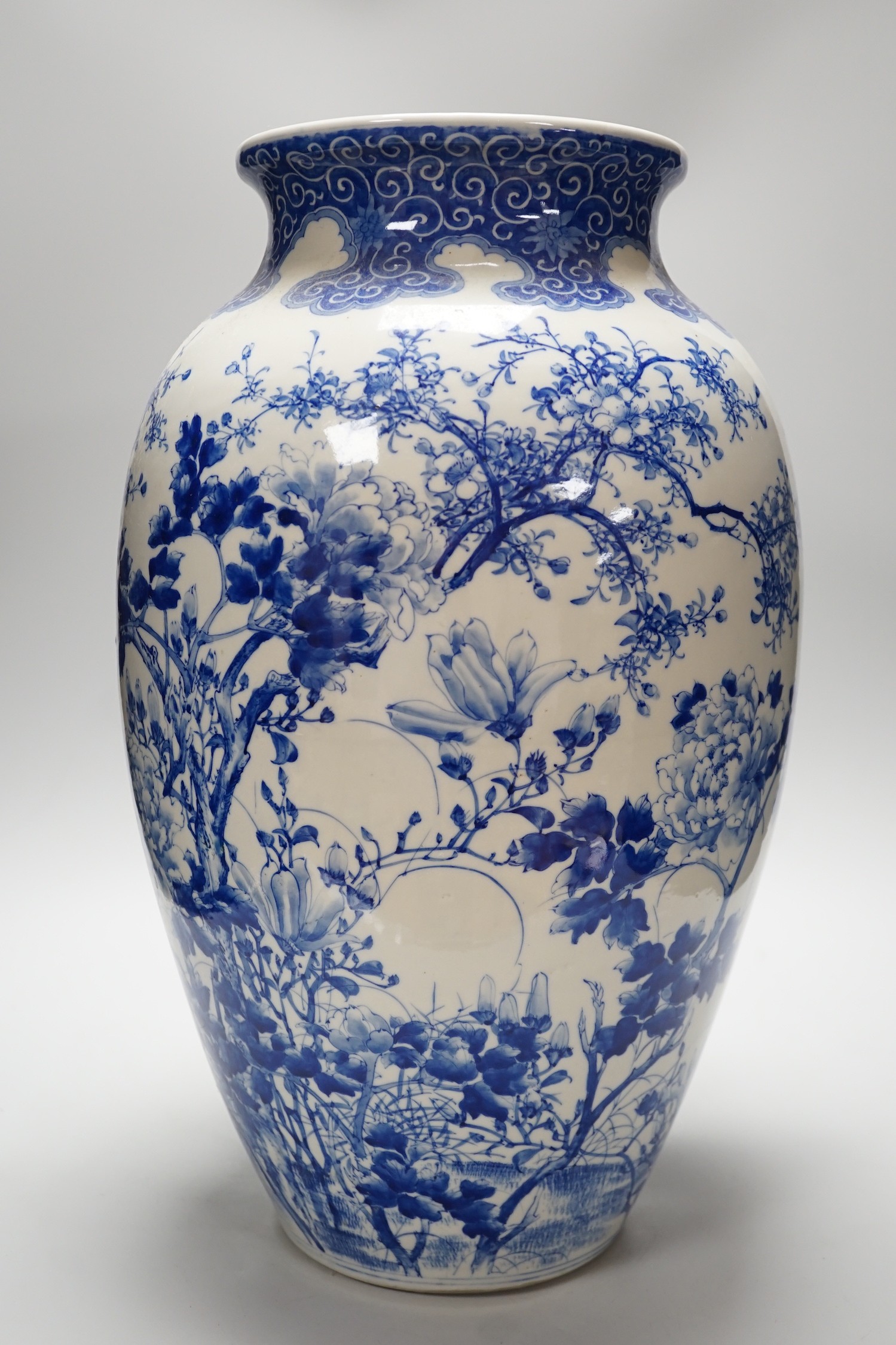 A large Japanese blue and white vase decorated with foliage and birds, 49cms high